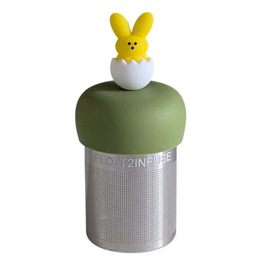 yellow peep bunny hatching from a white egg tea infuser for loose leaf tea with a fine mesh stainless steel tea strainer that reads FLOAT2INFUSE on a green base with a white background