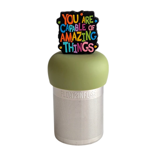 Text that reads "You are capable of amazing things" in bright rainbow font tea infuser for loose leaf tea with a fine mesh stainless steel tea strainer that reads FLOAT2INFUSE on a green base with a white background